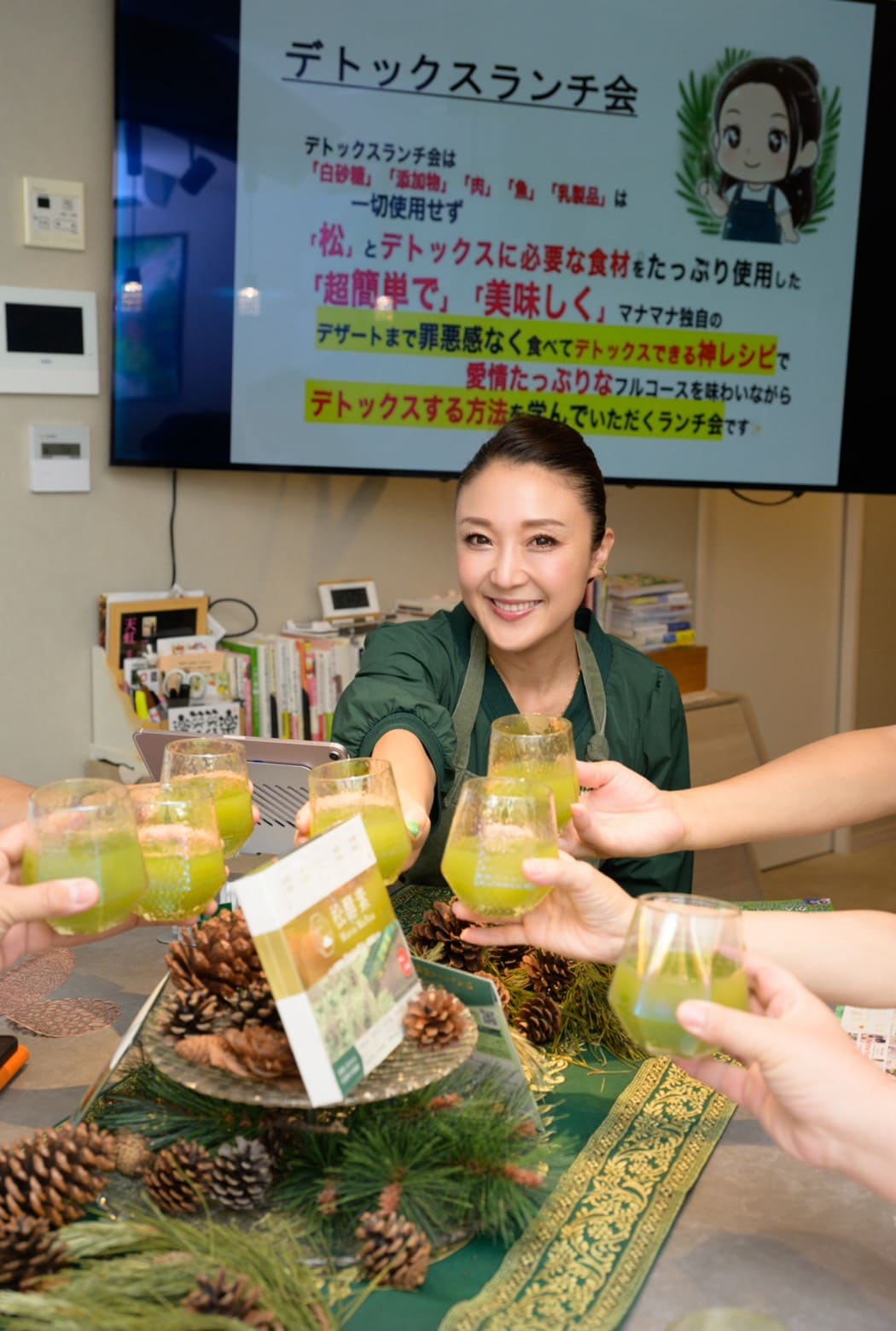 特製松葉ジュースのグラスを掲げて参加者と笑顔で乾杯する山﨑まな